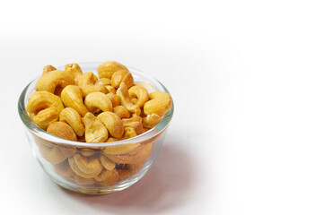 Cashew nuts in clear glass cup on white background