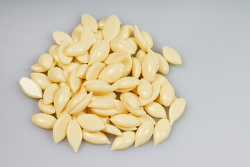 Heap of depilatory wax granules  on a gray background. White hot film wax for depilation close up. 