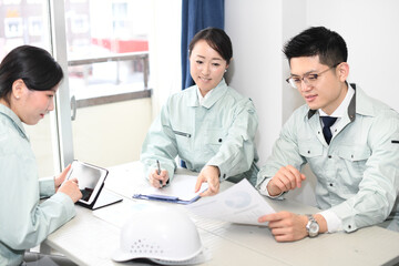 Obraz premium オフィスで会議をする作業服を着た男性と女性 