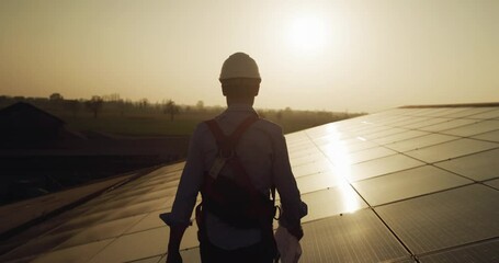 Maintenance assistance technical worker in uniform is smiling satisfied of his work after checking operation and efficiency performance photovoltaic solar panels on roof at sunset. clean green energy - Powered by Adobe