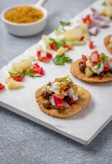 kala chana chaat papdi with boiled potato, tomato, onion, and coriander with a sprinkle of sev bhujia