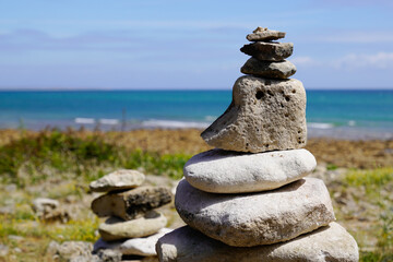 Fototapeta na wymiar Pile of some pebbles zen balanced stones stack on sea water coast beach