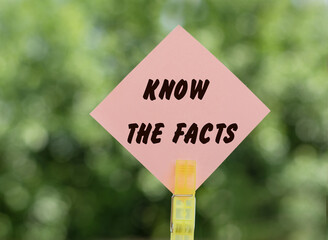 KNOW THE FACTS - text on pink note paper on green background.