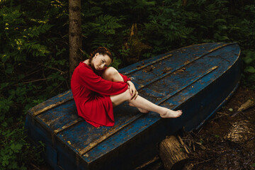 Fototapeta premium The young woman sitting on blue boat.