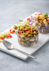black gram or kala chana chaat with boiled potato, onion, tomato with a dash of lemon juice served on  glass bowls