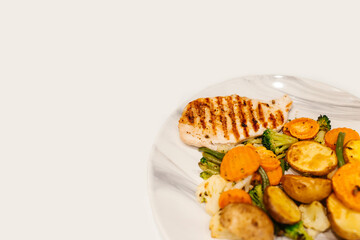 Grilled vegetables and chicken fillet on plate.