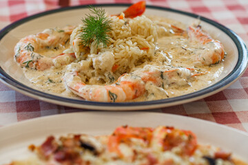 Prawns cooked, shrimps with rice, risotto with white sauce, on plate.