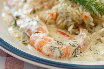 Shrimps cooked, prawns with rice, risotto with white sauce, on plate.