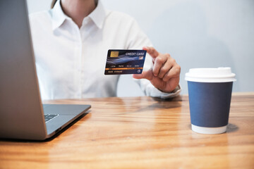 Woman holding credit card and using laptop computer. Online shopping concept.