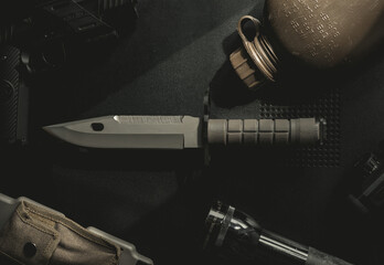 Top down photo of a knife, bayonet, tabletop.