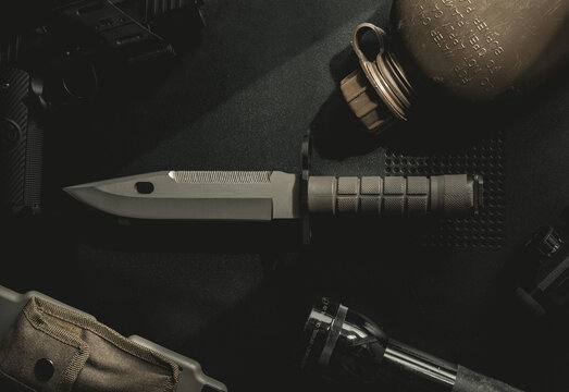 Top down photo of a knife, bayonet, tabletop.