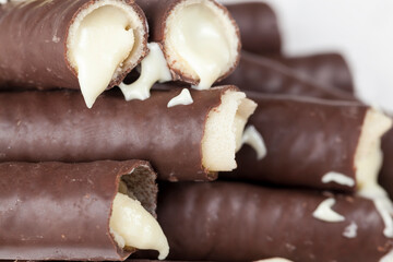 milk filling flows out of waffle tubes in chocolate