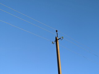 electric pole with wires against the blue sky
