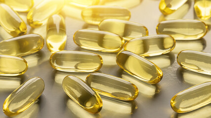 Prevention of vitamin deficiency. Yellow transparent fish oil capsules on gray. Backgrounds and textures.