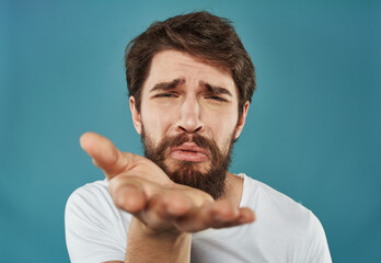 Man gesturing with his hands on a blue background closeup portrait of emotion