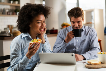 Loving couple drinking coffee and eating sandwich. Happy smiling wife enjoy in the morning with her husband
