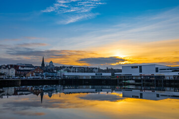Fototapeta premium Reflection of a coastal town as the sun sets