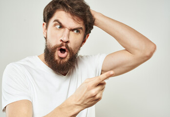Aggressive man in a white T-shirt irritability emotions light background