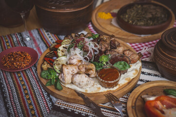 The richly laid table dishes of Georgian cuisine, lots of delicious food,wine,fruits and roasted meat