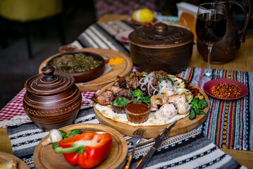 The richly laid table dishes of Georgian cuisine, lots of delicious food,wine,fruits and roasted meat