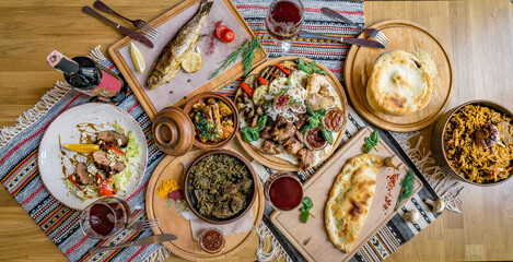 A lot of food on the wooden table. Georgian cuisine. Top view. Flat lay . Khinkali and Georgian dishes