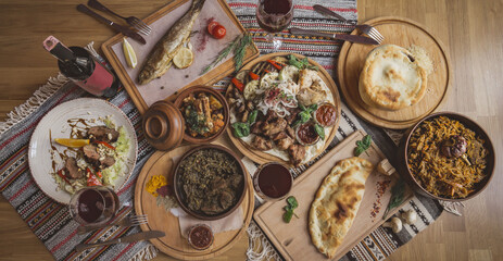 A lot of food on the wooden table. Georgian cuisine. Top view. Flat lay . Khinkali and Georgian dishes