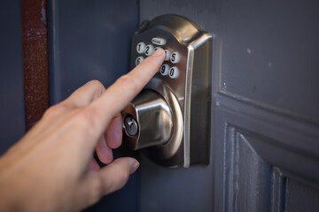Caucasian female hand pressing buttons door entry key pad open entrance security lock protect home front airbnb
