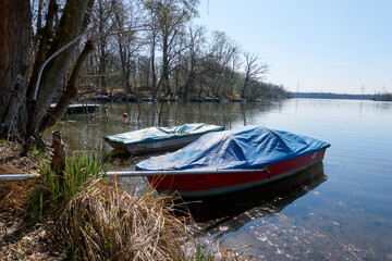 several boats in different colors are lying at a lake