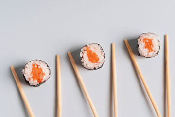 Simple rice and salmon rolls with chopsticks