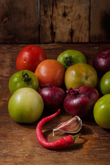 Seasonal harvest, autumn vegetables, hot pepper, garlic, unripe green tomatoes. Local farmer organic no animal products. Copy space, vertical shot