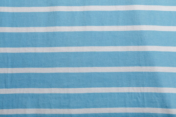 Texture of blue and white striped cotton wrinkled fabric, background or backdrop. Clothing, sewing,...