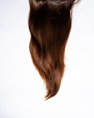 Naklejka premium Dark hair curls lie on white background