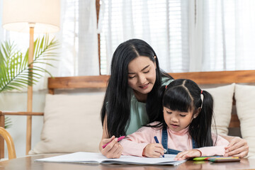 Asian girl drawing and painting picture with mother in the living room
