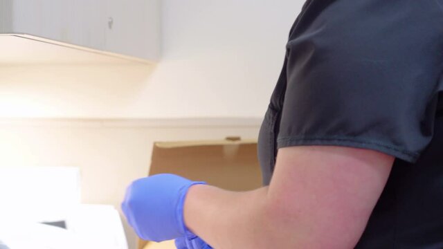 Nurse Opens Steral Vaccine Seringe from Package While Wearing Gloves to Prepare the COVID 19 Shot or Corona Virus Injection in Medical Doctor&rsquo;s Office with No Faces
