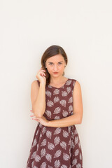 Serious beautiful woman outdoors againt plain wall vertical shot