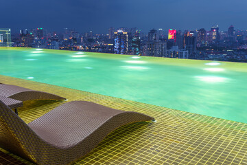 Relaxing chairs on Infinity pool with Hanoi skyline on background