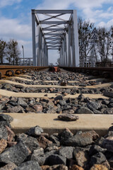 A close-up on rails and a railway bridge. Perspective photo taken on a sunny day.