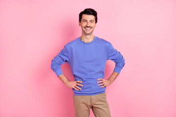 Photo of charming happy attractive young guy hold hands waist good mood isolated on pink color background