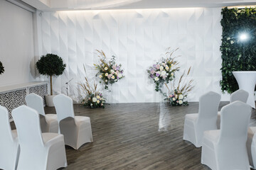 wedding reception area with fresh flowers in the white hall