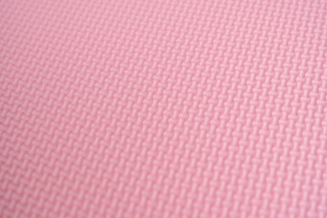 The surface of the pink foam rubber floor tiles. Selective focus