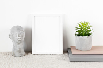 Small white photo frame mockup with books and flowerpot