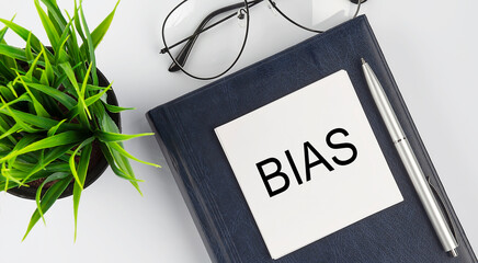 Stickers on notebook text BIAS with pen and glasses on white background