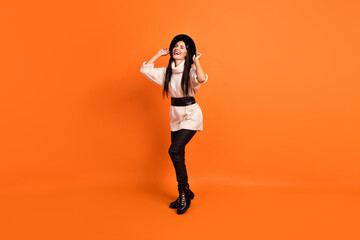 Fototapeta na wymiar Full size photo of young gorgeous beautiful smiling dreamy funky woman dancing isolated on orange color background