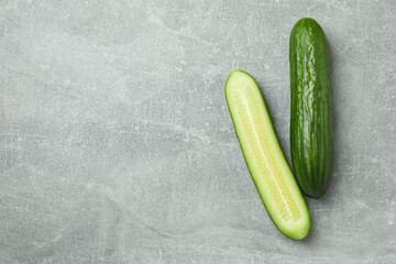 Ripe cucumbers on gray background, space for text