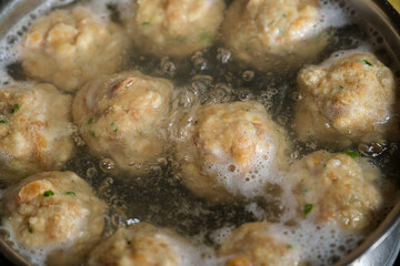 Bayerische Knödel / Semmelknödel / Semmelnknödeln in kochendem Wasser in eine Topf in der Küche