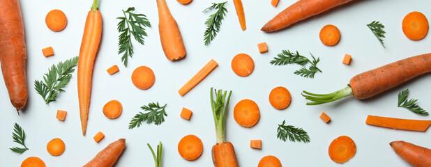 Carrots, slices and leaves of carrot on white background