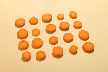 Slices of fresh carrot on beige background