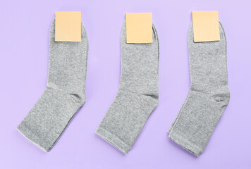 Soft cotton socks on lilac background, flat lay