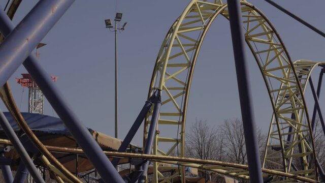 An abandoned, rust-covered roller coaster ride in an abandoned amusement park.
