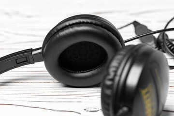 Obraz na płótnie Canvas Black headphones with wire on wooden background
